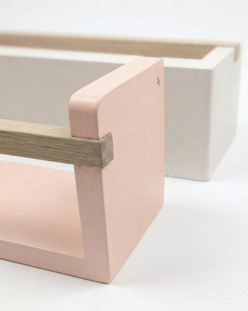 Minimalist wooden stool with a light pink seat on a white background