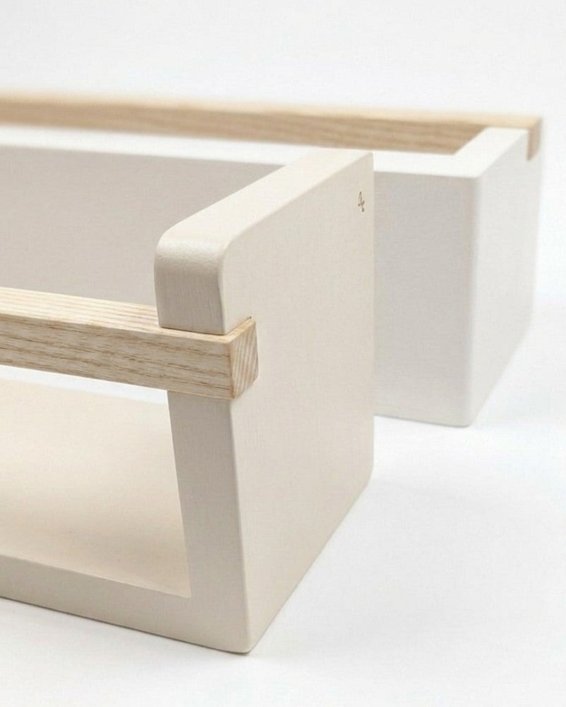 Minimalist white chair with wooden armrests on a light background