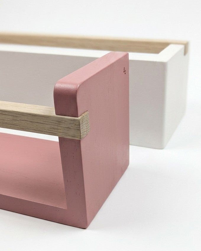 Minimalist wooden shelf with pink base on a white background