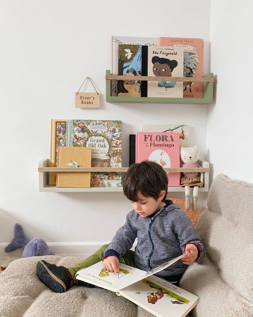 Young child reading beside Autumn's Corner Colour Pop bookshelf in Olive and Hessian, handcrafted solid wood