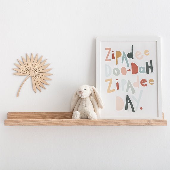 Solid ash Book and Picture Ledge by Autumn's Corner holding a framed print and a toy bunny
