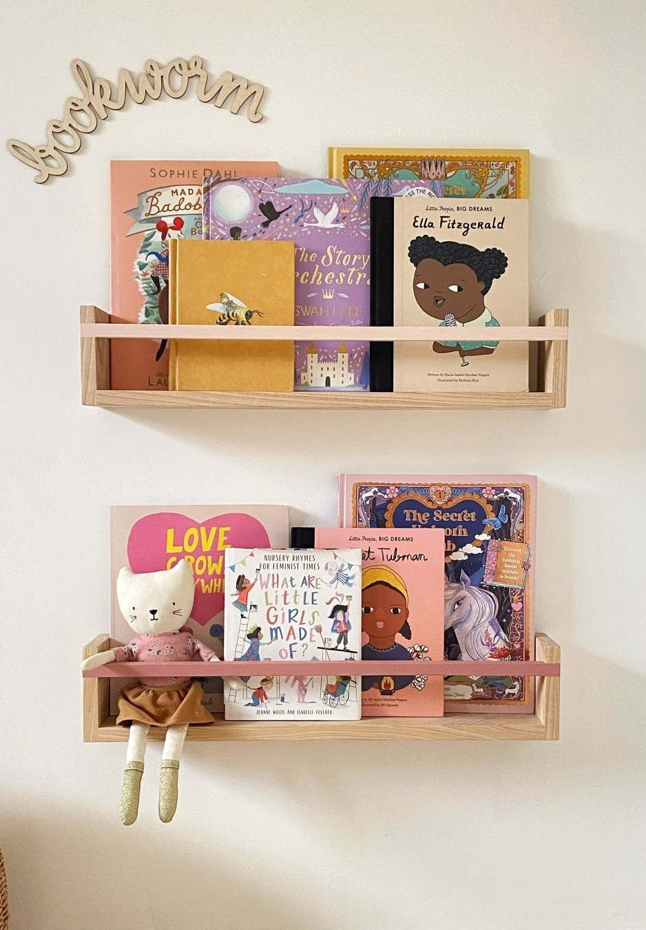 Wooden bookshelf with children's books and toys against a white wall